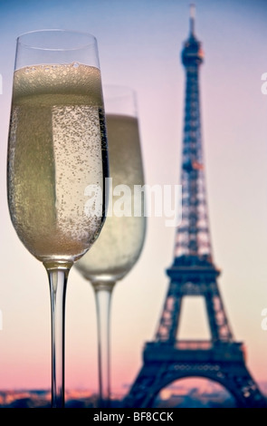Terrasse avec vue sur PARIS CHAMPAGNE deux verres de champagne à la Tour Eiffel au coucher du soleil derrière. Paris France Banque D'Images