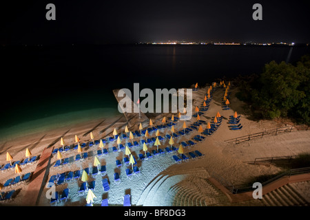 Hôtel la mer plage avec chaises longues et parasols jaune bleu de nuit Banque D'Images