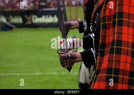 Les fiers marcheurs de la Lonach Highlanders, portant manteau plaid tartan rouge Wallace assistant à la Scottish Highland Games à Donside, Ecosse, Royaume-Uni Banque D'Images