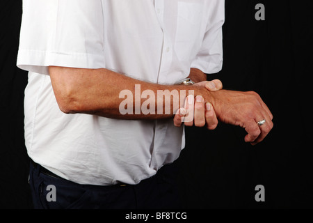 La fin de l'homme d'âge moyen holding articulation du poignet douloureux de souffrir avec la douleur d'arthrite chronique ou RSI accident du travail Banque D'Images