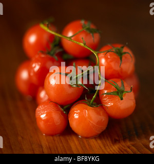 Tomates cerises rouges assis sur une surface en bois Banque D'Images