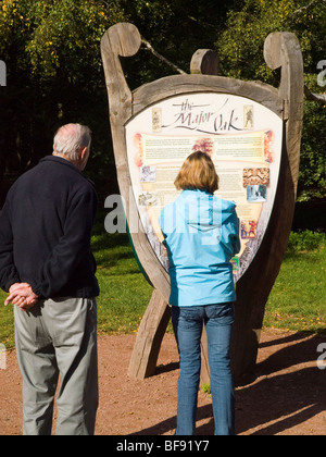À un couple à la recherche d'informations sur le grand chêne dans la forêt de Sherwood, Lancashire England UK Banque D'Images