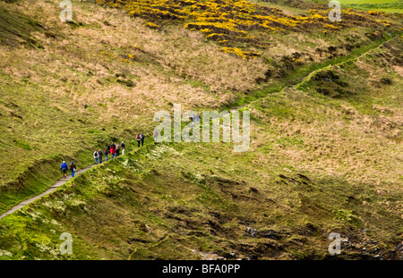 Les randonneurs à faire leur chemin vers le haut un chemin le long des falaises au-dessus de Boscastle Harbour à Cornwall, Angleterre Banque D'Images