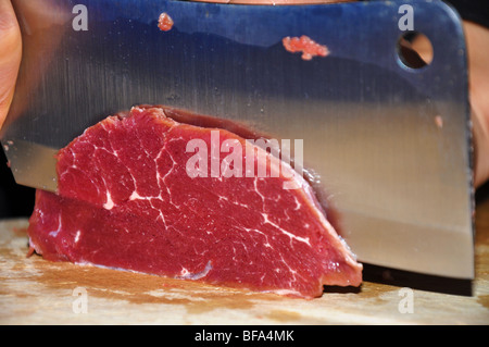 Rencontrez boeuf frais coupés avec un couteau de boucher sur une planche à découper. Banque D'Images