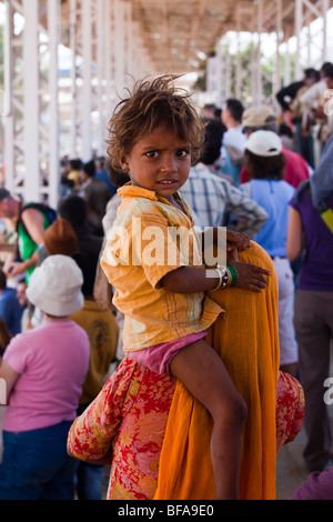 Petit enfant à cheval sur les épaules de la mère à la foire de chameau à Pushkar Inde Banque D'Images