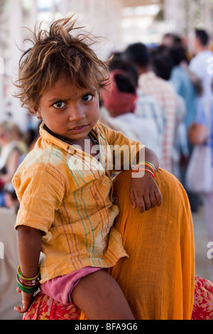 Petit enfant à cheval sur les épaules de la mère à la foire de chameau à Pushkar Inde Banque D'Images