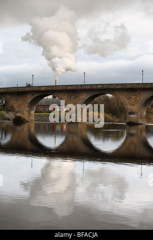 Panache d'échappement à partir de l'usine d'agglomérés Egger vue reflétée dans la rivière Tyne à Hexham, Northumberland, England, UK Banque D'Images