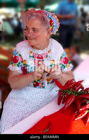 Les vieilles femmes en robe traditionnelle à l'paprka Kalocsa festival cordes faisant de piments. Kalocsa, Hongrie Banque D'Images