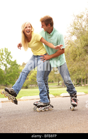 Couple Wearing à roues alignées dans la région de Park Banque D'Images