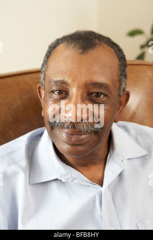 Senior Man Relaxing in Chair At Home Banque D'Images