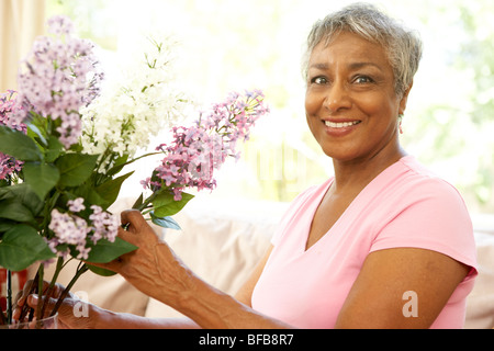 Senior Woman l'Organisation de la fleur à la maison Banque D'Images