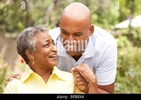 Senior Woman câlins par fils adultes Banque D'Images