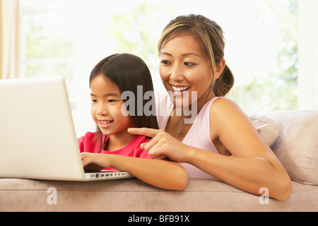 Mère et fille à l'aide d'ordinateur portable à la maison Banque D'Images