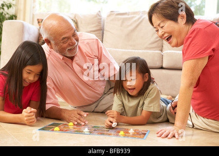 Les grands-parents et petits-enfants jouant à la maison du jeu de société Banque D'Images