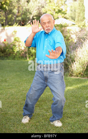 Man faisant de Tai Chi dans le jardin Banque D'Images