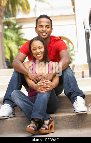 Jeune couple assis sur les étapes de la construction Banque D'Images