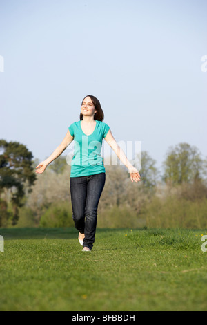 Adolescente qui traverse l'été Meadow Banque D'Images