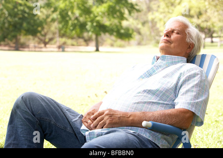 Senior Woman Relaxing In Park Banque D'Images