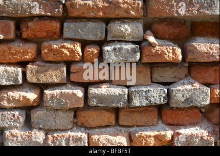 Gros plan de vieux mur de briques rouges avec des briques endommagées, textures urbaines Banque D'Images