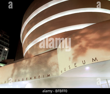 Lumières de rue d'ombres d'arbres sur le musée Guggenheim (conçu par Frank Lloyd Wright), la ville de New York. Photo de nuit. Banque D'Images