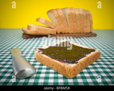 Une tranche de pain avec du bourrage. Miche de pain sur l'arrière-plan. Banque D'Images