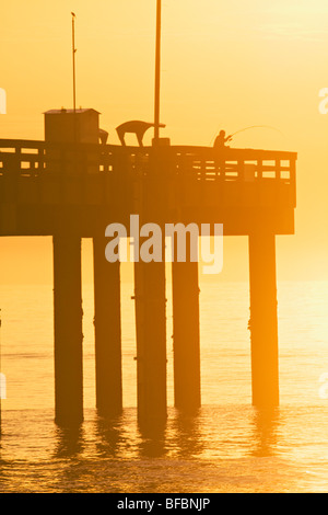 Pêcheur sur une jetée de saint Augustin au lever du soleil. Banque D'Images