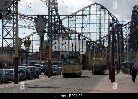 Les trams s'exécutant sur le Golden Mile avec Blackpool Pleasure Beach à l'arrière-plan. Banque D'Images