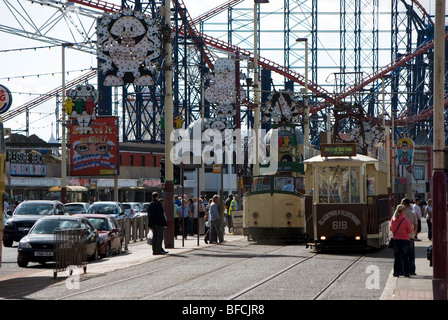 Les trams s'exécutant sur le Golden Mile avec Blackpool Pleasure Beach à l'arrière-plan. Banque D'Images