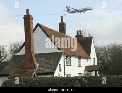 Avion survolant house en approche sur l'aéroport de Stansted, Essex, UK Banque D'Images