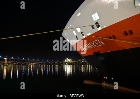 MS Finnmarken Hurtigruten à Tromso, Norvège du Nord. L'église de l'Arctique à l'arrière-plan. Banque D'Images