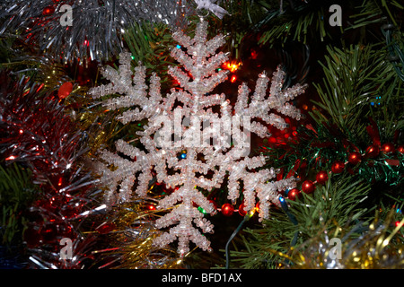 Décoration flocon suspendu à un arbre de Noël artificiel Banque D'Images