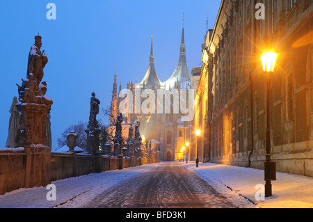 Rue couverte de neige à travers un pont vers l'église Sainte Barbara à Kutná Hora. Banque D'Images