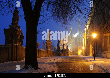 Rue couverte de neige à travers un pont vers l'église Sainte Barbara à Kutná Hora. Banque D'Images