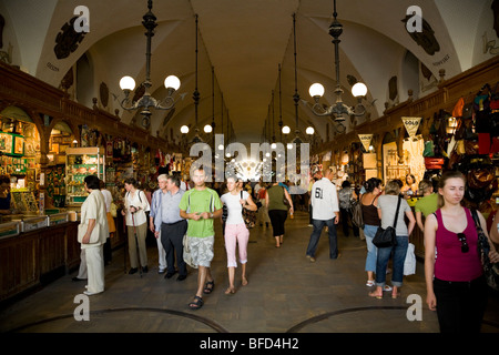 Les touristes et l'intérieur de la Halle aux Draps (Sukiennice, drapiers' Hall) dans la place du marché. Cracovie. Pologne Banque D'Images