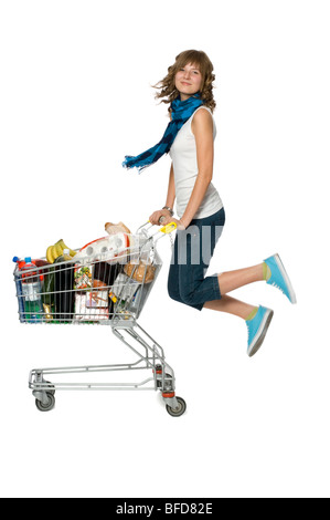 Young woman holding shopping cart et le saut Banque D'Images