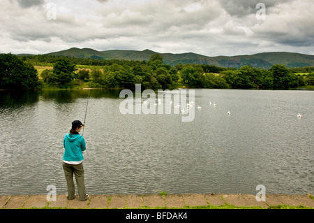 Femme pêchant sur la rive du barrage de Gartmorn en Écosse. Banque D'Images