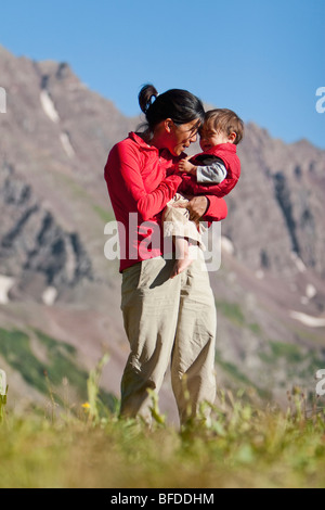 Mère joue avec son fils de 14 mois dans la région de prairie alpine. Grande randonnée pédestre en Maroon Bells à Snowmass Wilderness en dehors de Aspen, Colorado Banque D'Images