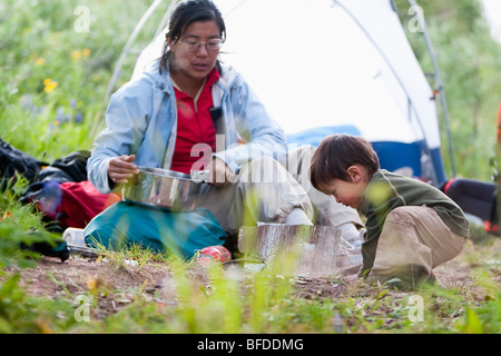 Mère prépare le dîner tandis que 14 mois fils joue en camping. Fravert dans le bassin Maroon Bells Snowmass Wilderness Colorado. Banque D'Images