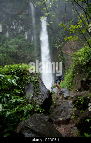 Un randonneur sous une cascade dans la jungle au Costa Rica. Banque D'Images