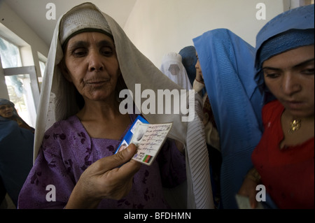 Les femmes tiennent leur carte d'enregistrement alors qu'elles font la queue pour voter au lycée de filles Sultan Razia le jour de la présidence Banque D'Images