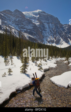 Un skieur faisant un River Crossing, dans la vallée du Paradis, Lake Louise, Banff National Park, Alberta, Canada Banque D'Images