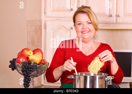 Belle femme blonde la cuisson des pâtes. Banque D'Images