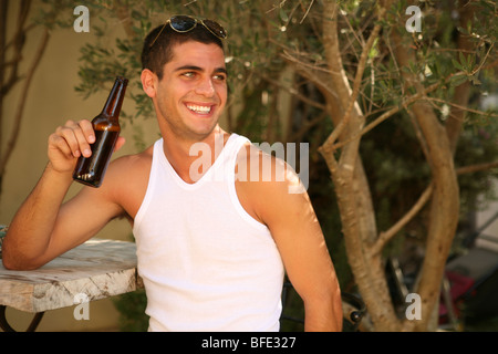 Jeune homme ayant la bière sur le bar. Banque D'Images