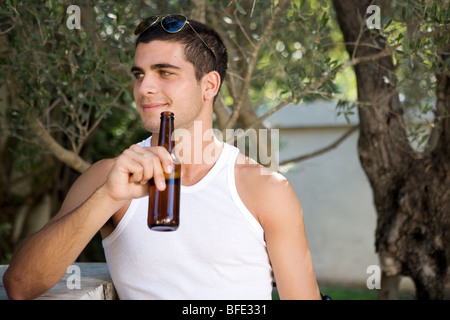 Jeune homme ayant la bière sur le bar. Banque D'Images