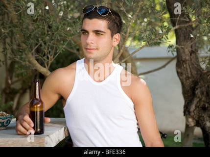 Jeune homme ayant la bière sur le bar. Banque D'Images