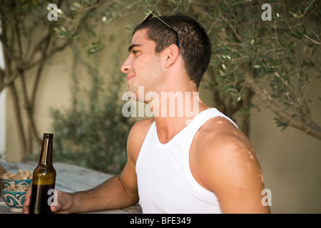 Jeune homme ayant la bière sur le bar. Banque D'Images