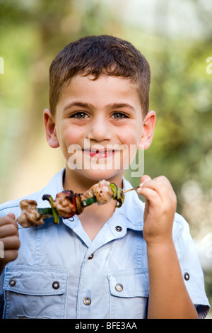 Boy eating une brochette, jour de l'indépendance. Banque D'Images