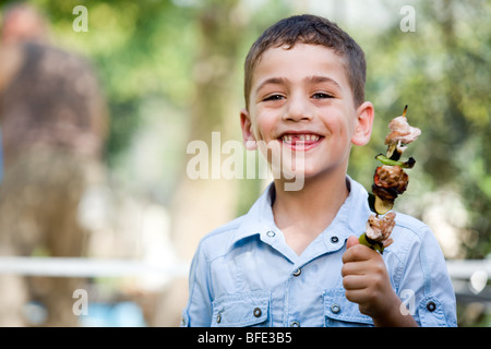 Boy eating une brochette, jour de l'indépendance. Banque D'Images