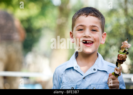 Boy eating une brochette, jour de l'indépendance. Banque D'Images