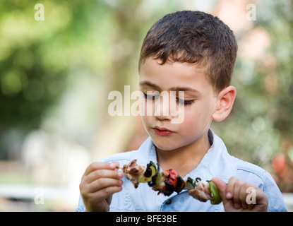 Boy eating une brochette, jour de l'indépendance. Banque D'Images